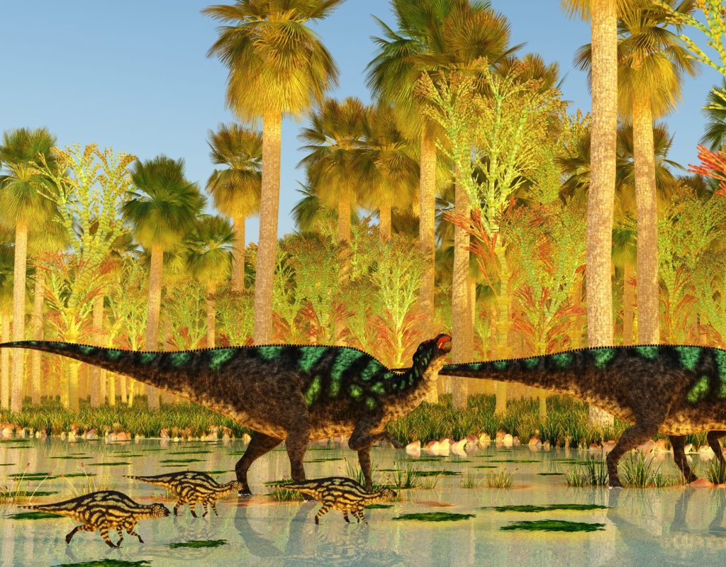 Two Maiasaura Hadrosaur dinosaurs escort their young across a swamp during the Cretaceous Period.